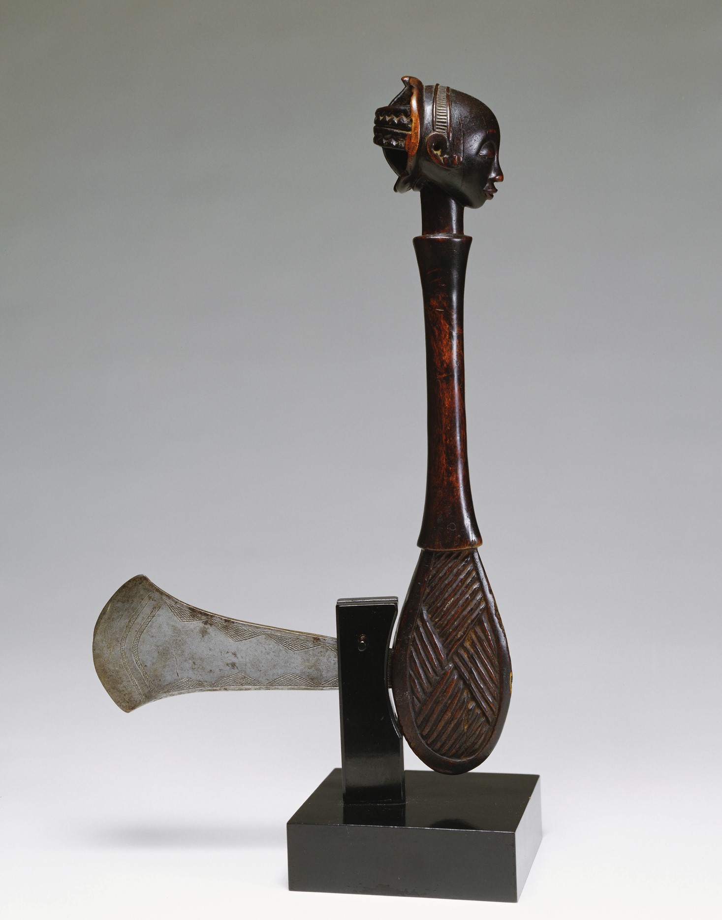 An axe with a wooden handle in the shape of a head and neck