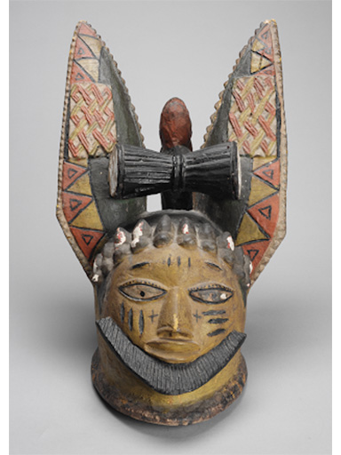 Image of a hunting headdress with a human face and tall animal ears.