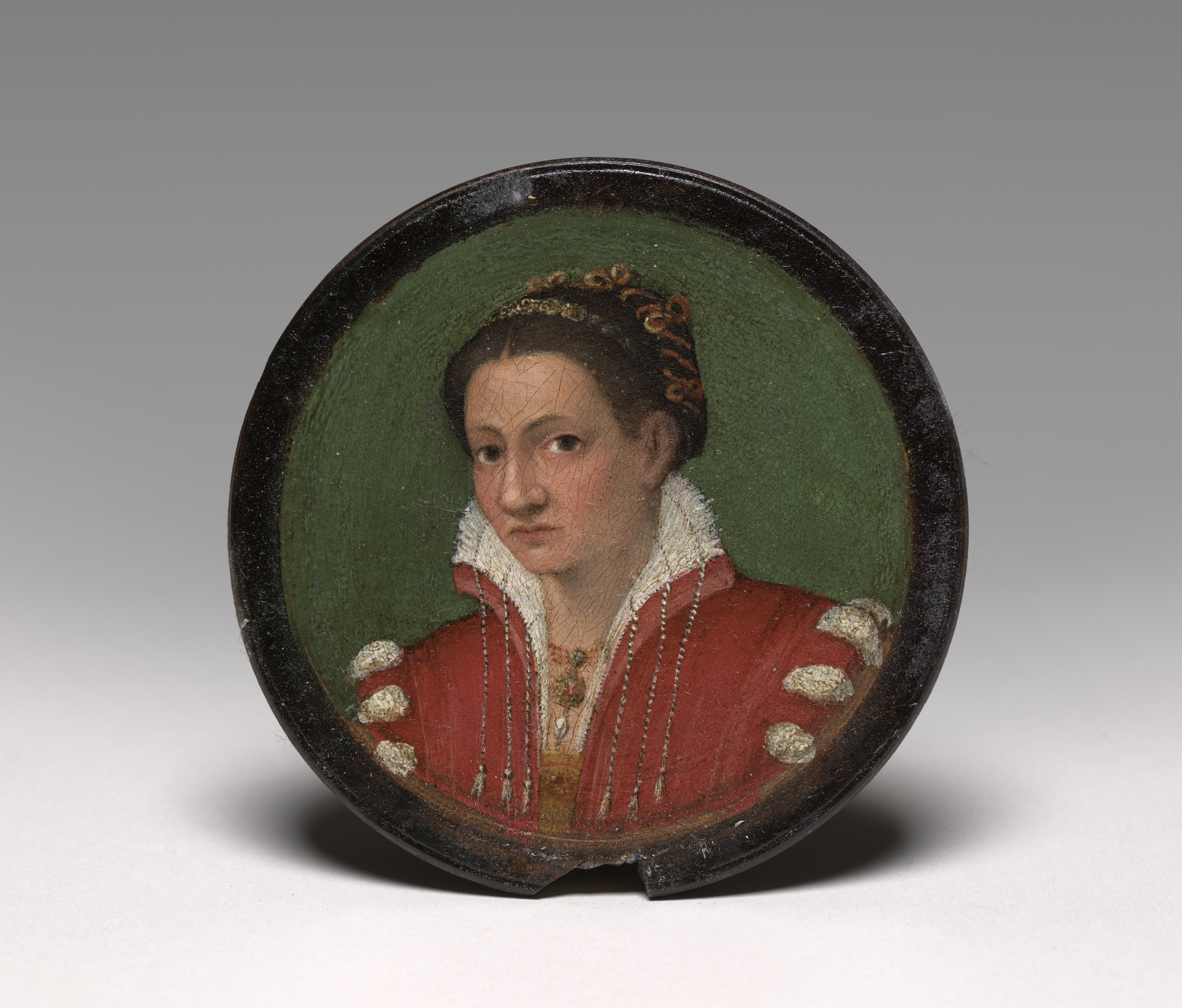 Portrait of a woman in a circular framed panel with dark hair in a bun and a red dress with ivory colored collar