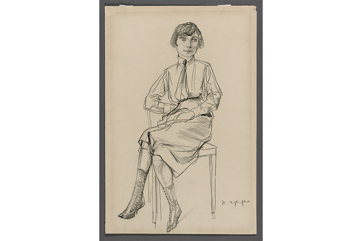 Charcoal drawing on cream paper of a woman with bobbed dark hair sitting cross-legged in a chair. She wears a button-up shirt, tie, knee-length skirt, and heeled boots with tiny buttons up the side.