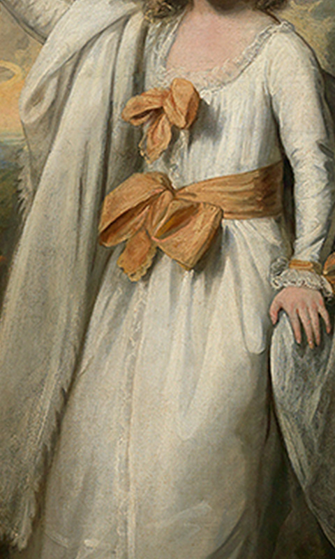 "detail shot of girl's white dress with coral sash"