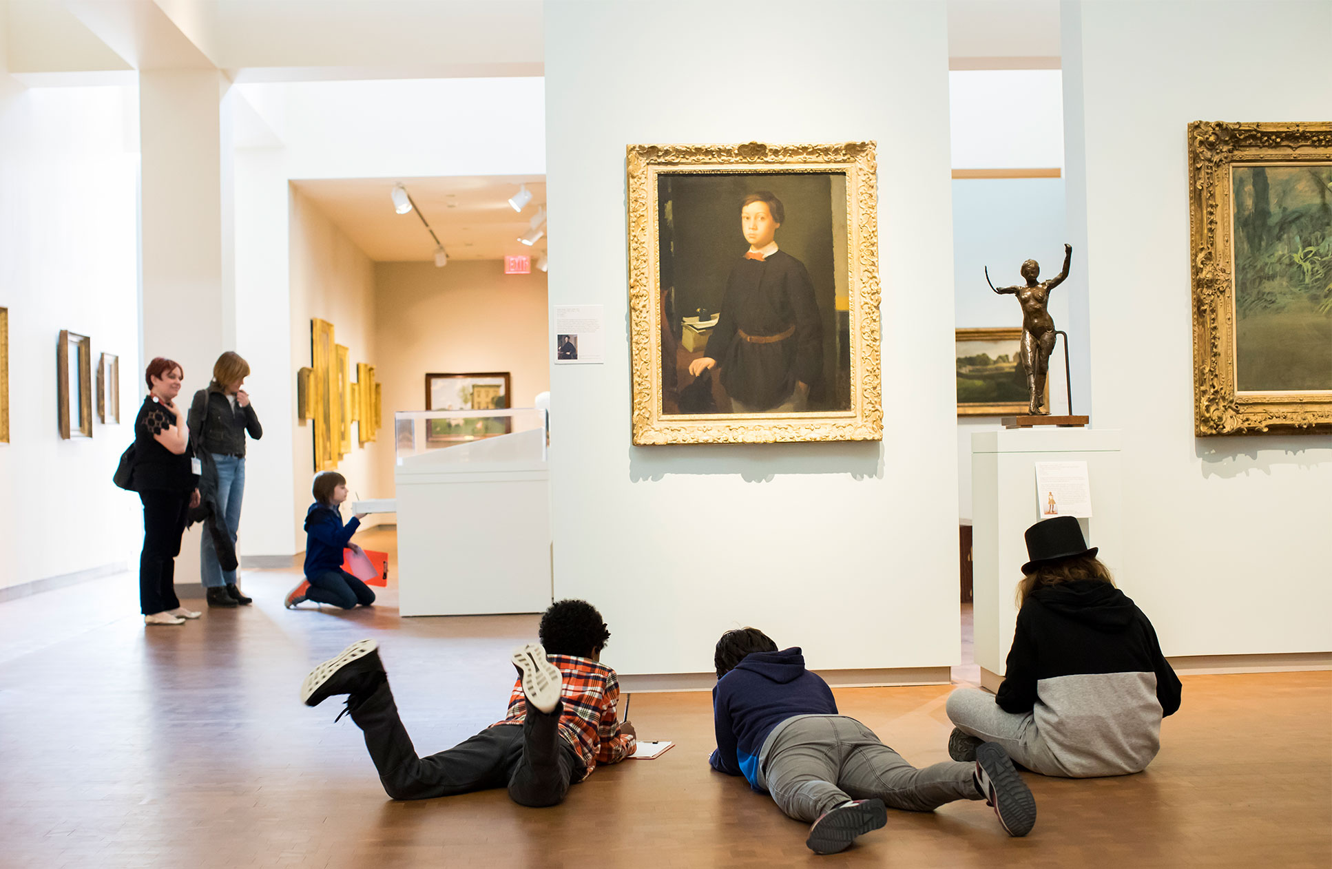 School visitors looking at and drawing art in the galleries