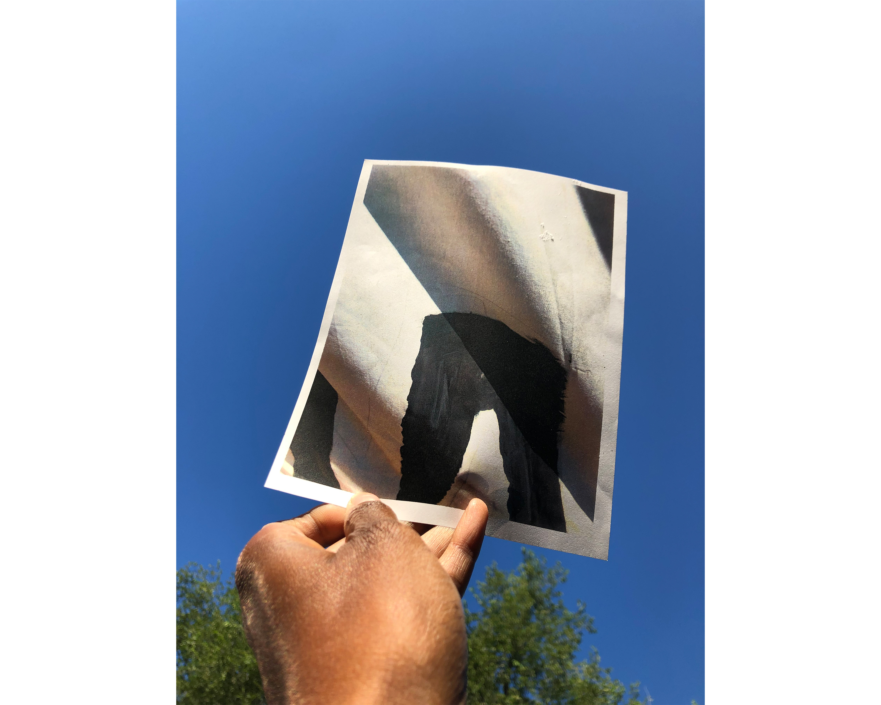 Amanda Williams holding up photo of a detail of a banner