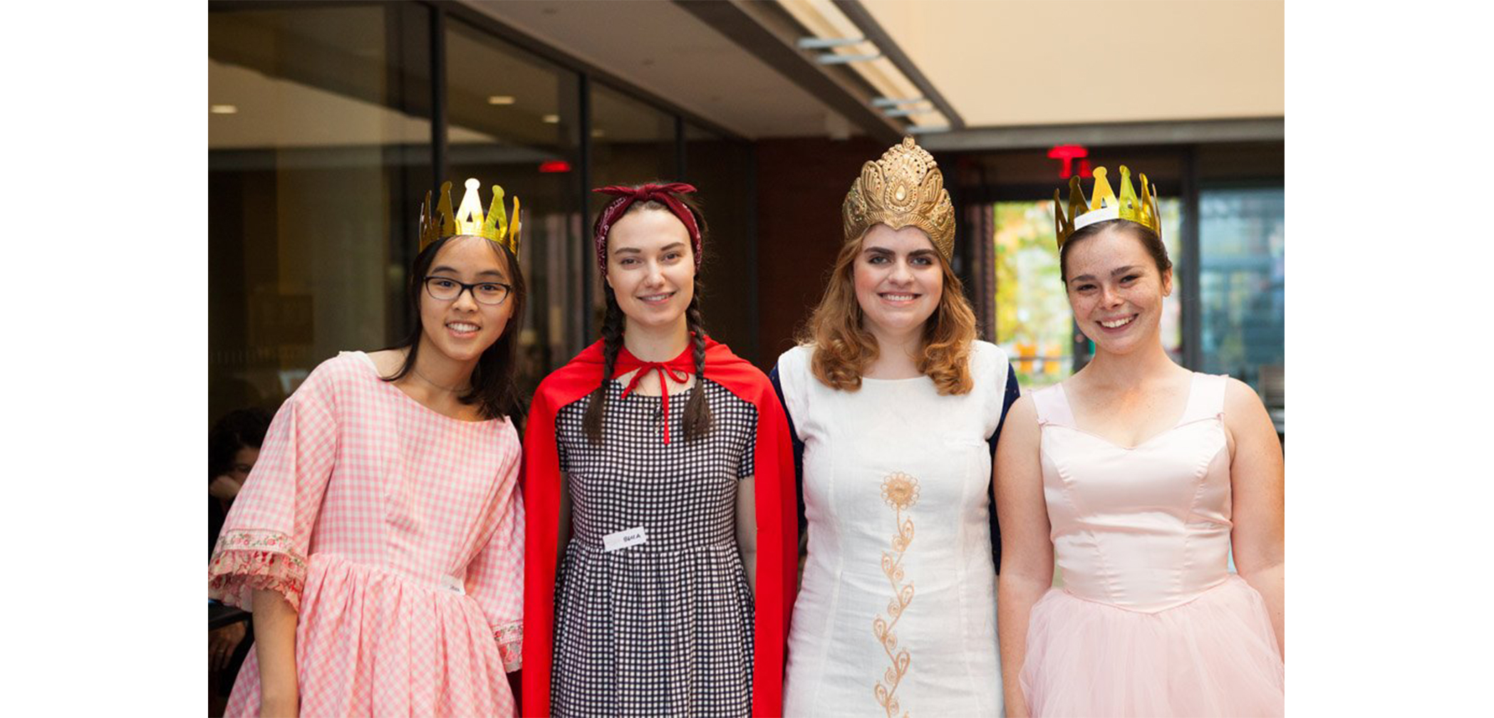 Four students with homemade crowns on in SCMA atrium