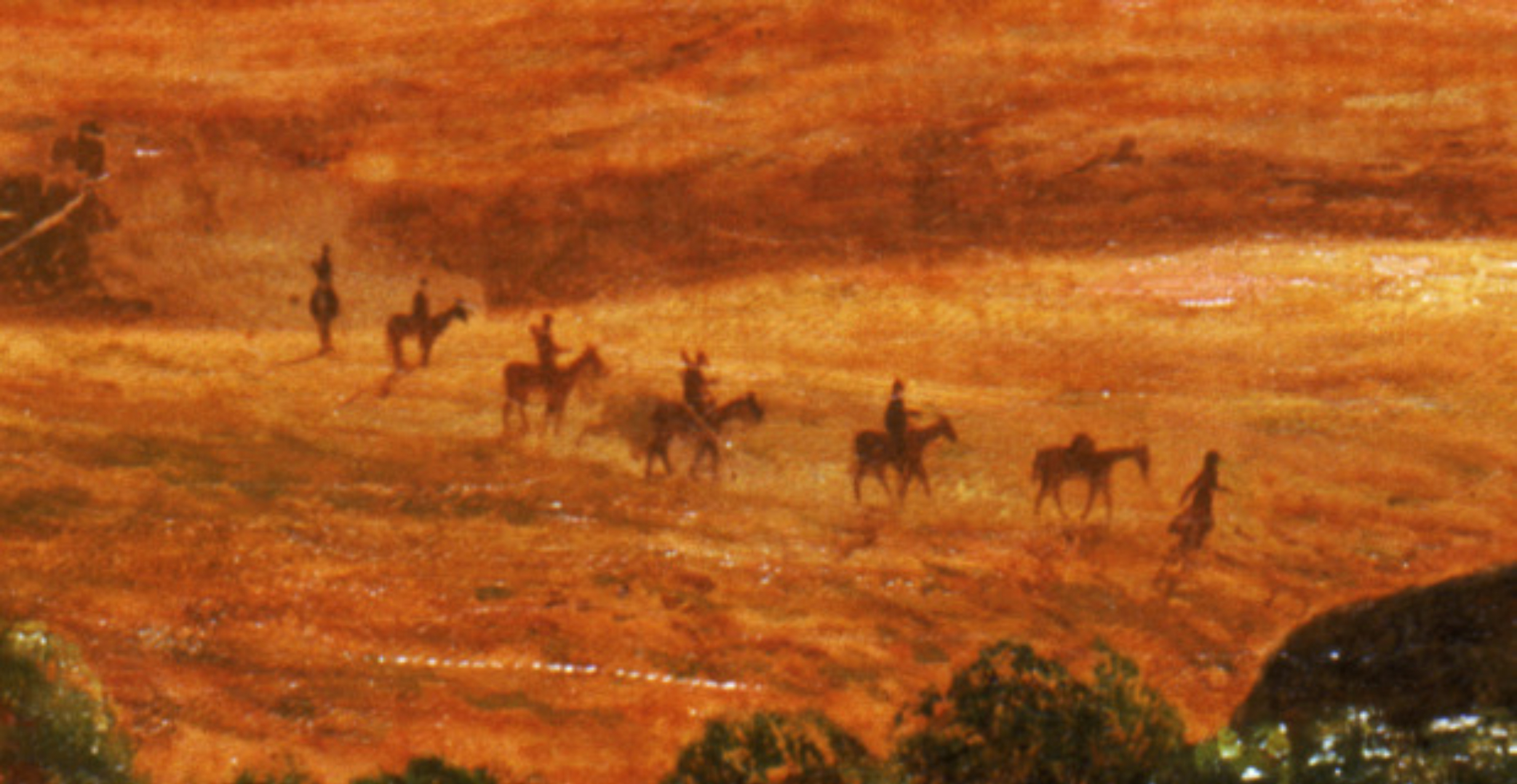 Detail: in a orange-gold valley, a collection of seven people, five on horseback, walk across the landscape in a line.