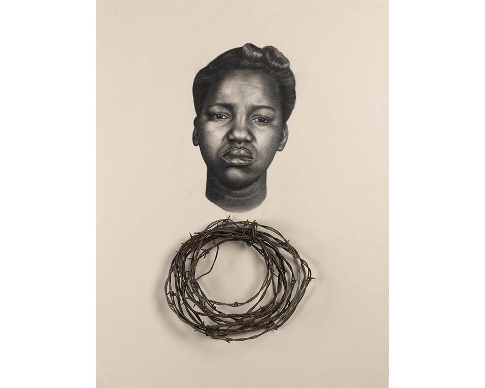 frontal head of a frowning African American woman with her hair in an up do over a circlet of real barbed wire encased in a black box