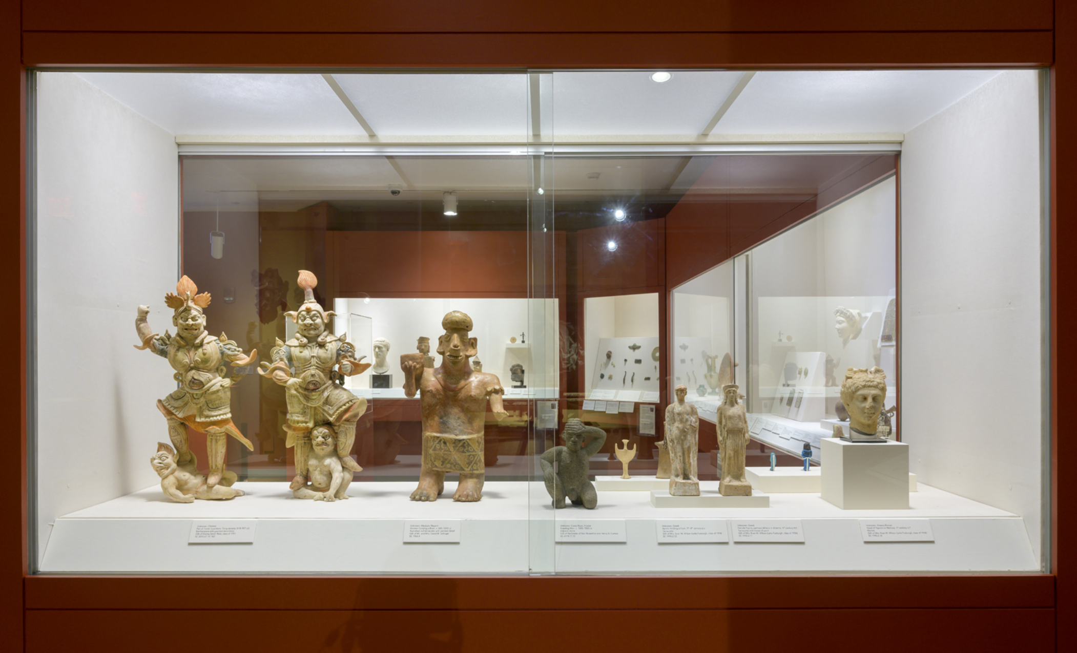 Collection of figurative stone objects in a display case