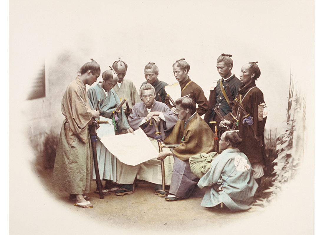 group of men in samurai clothing gathered around a scroll