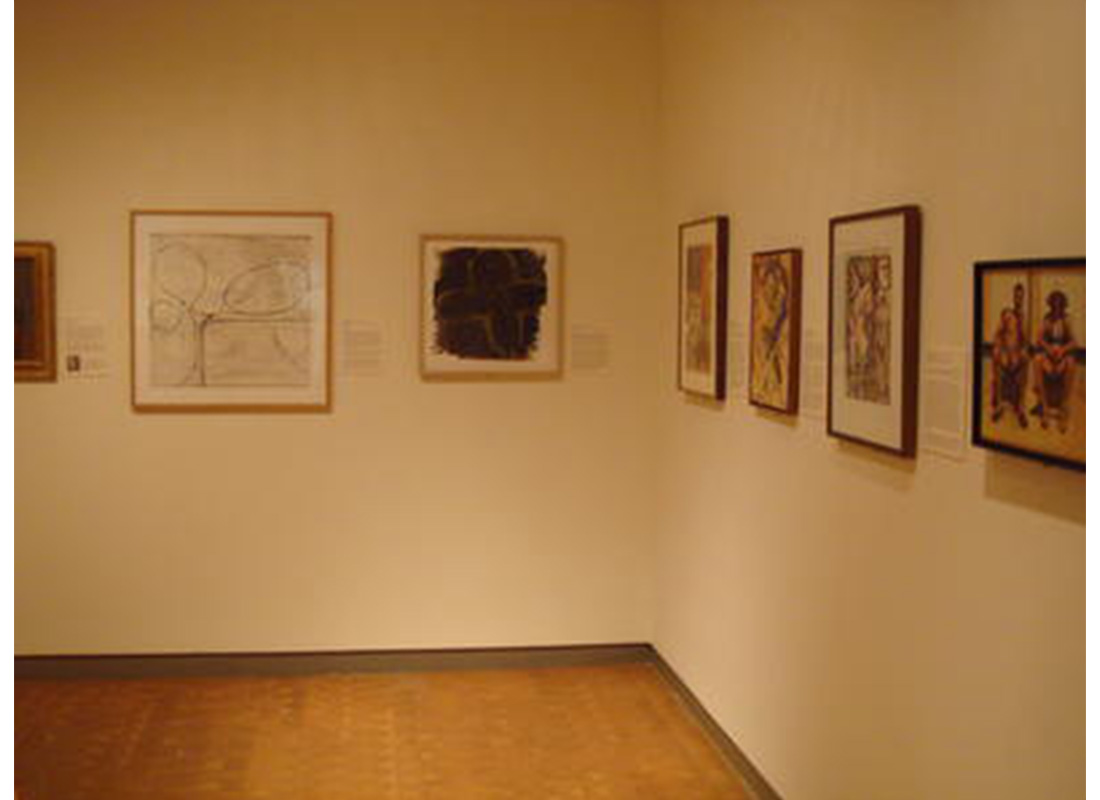 art gallery with two artworks hung on the back wall and four artworks hung on the right wall