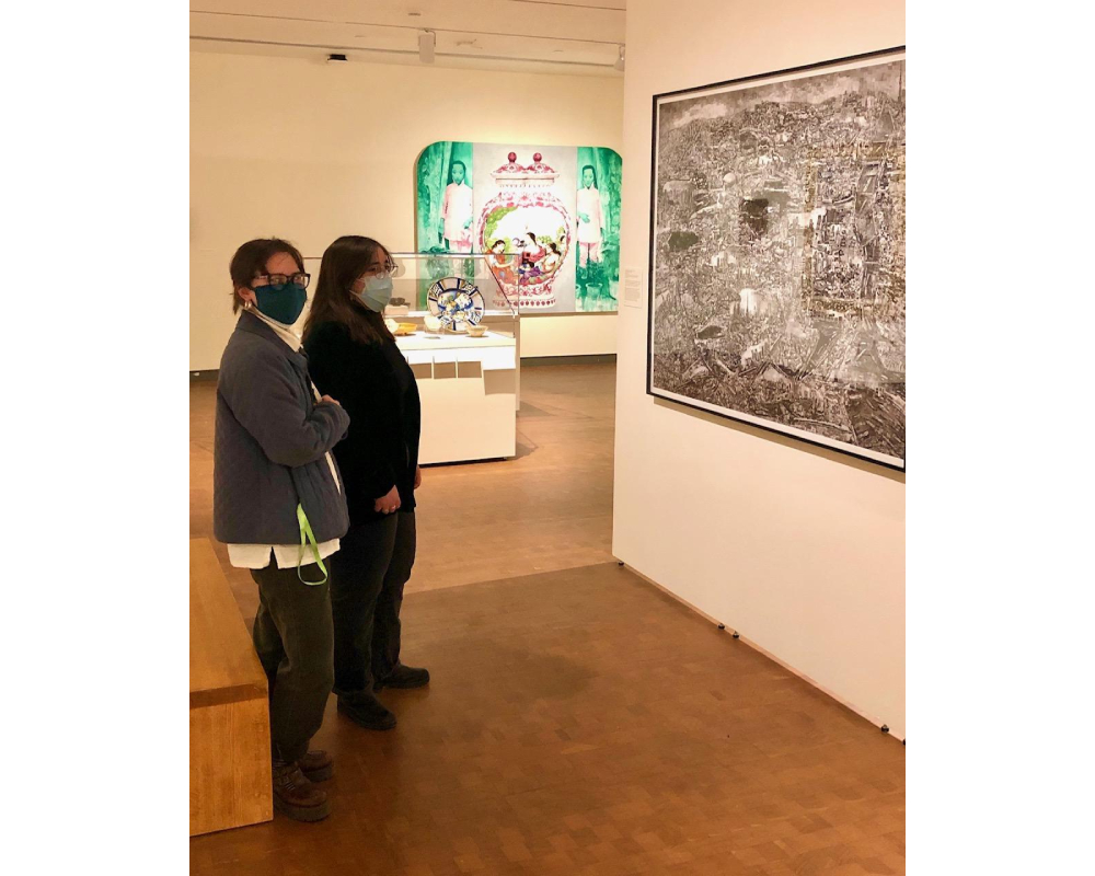 Two masked students observing a work in the gallery