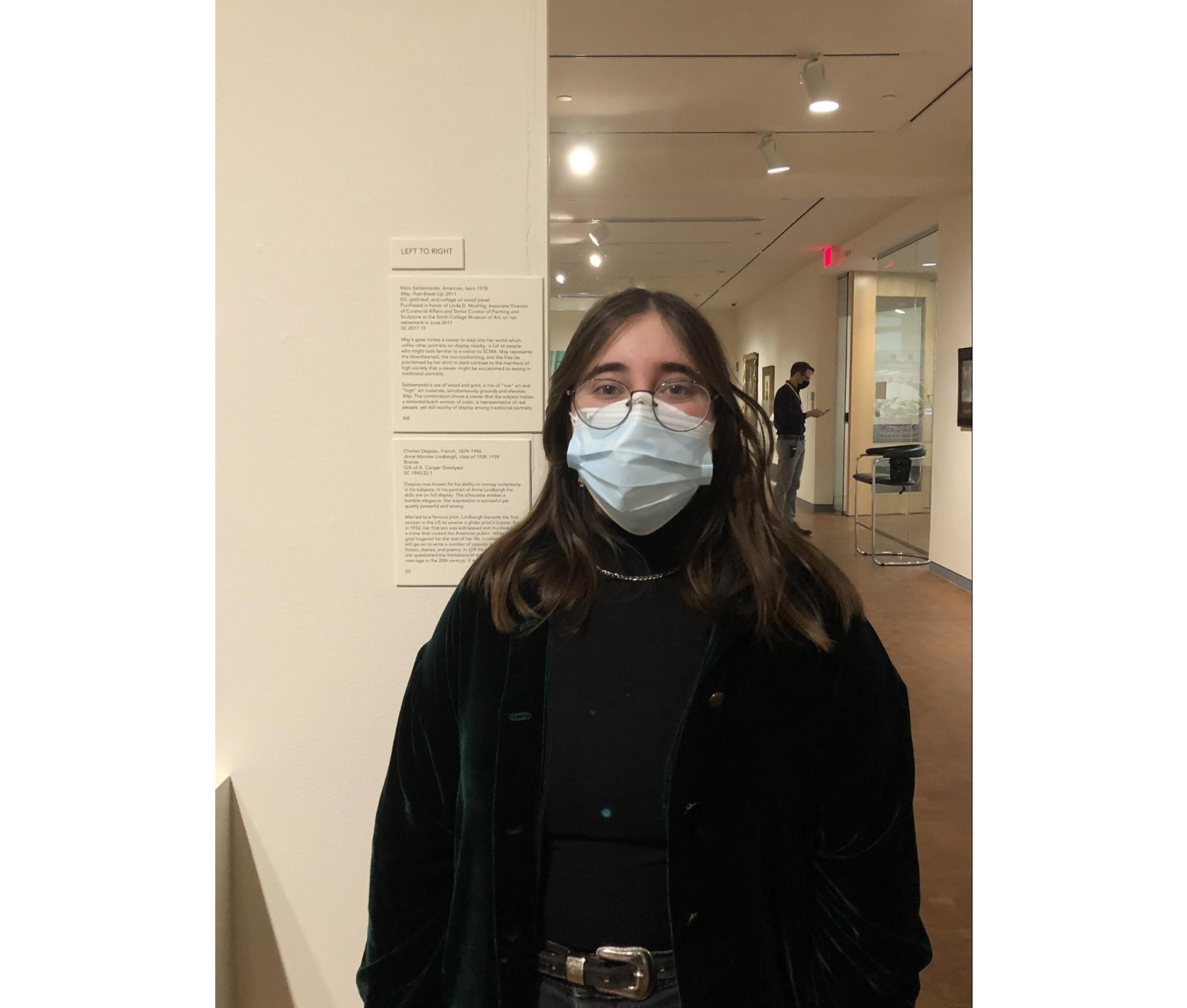 Masked student standing in front of an artwork label in an SCMA gallery.