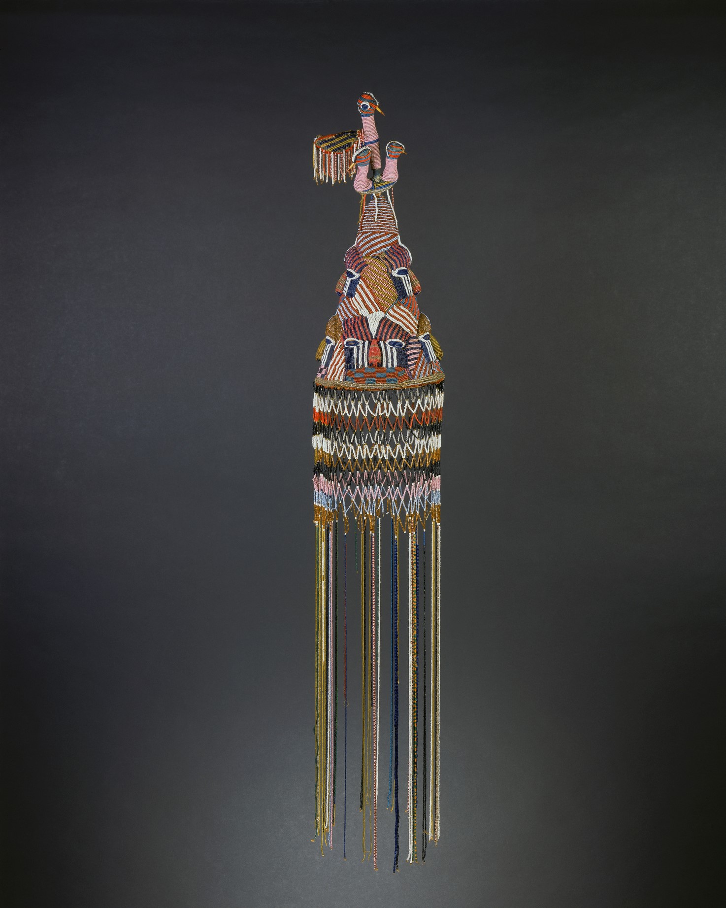 Beaded multi colored headdress with long beaded strings hanging off the rim on the bottom