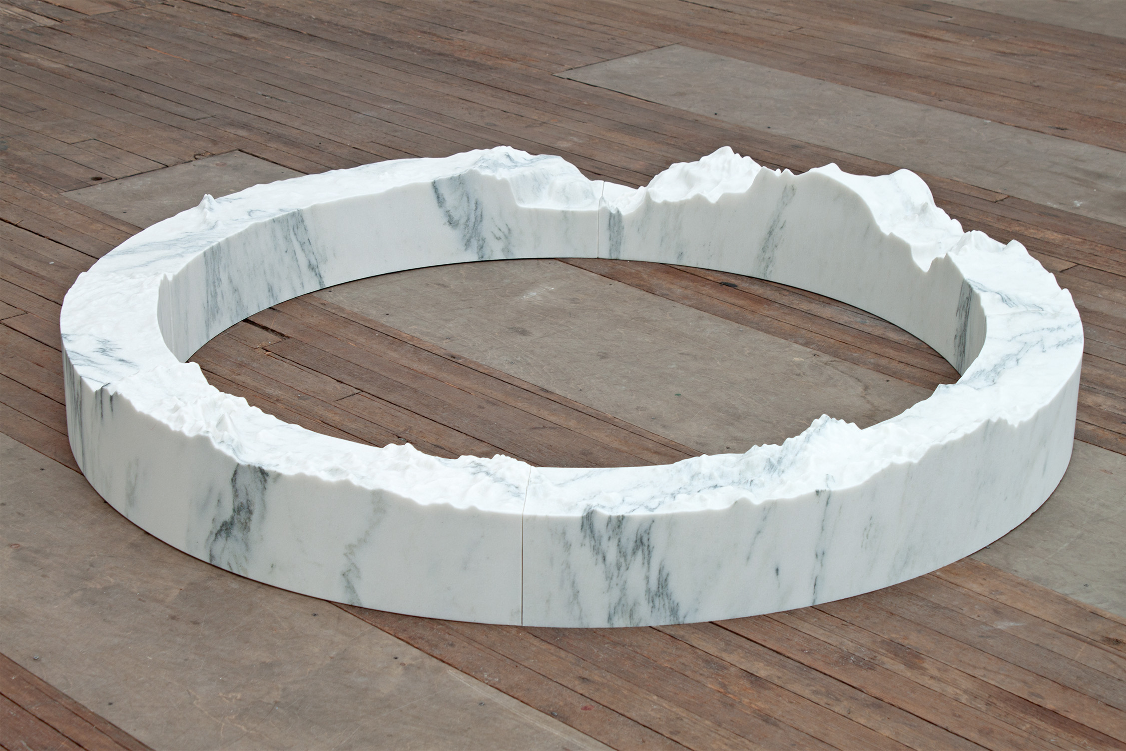 Large marble ring on a wooden floor with erratic top edges