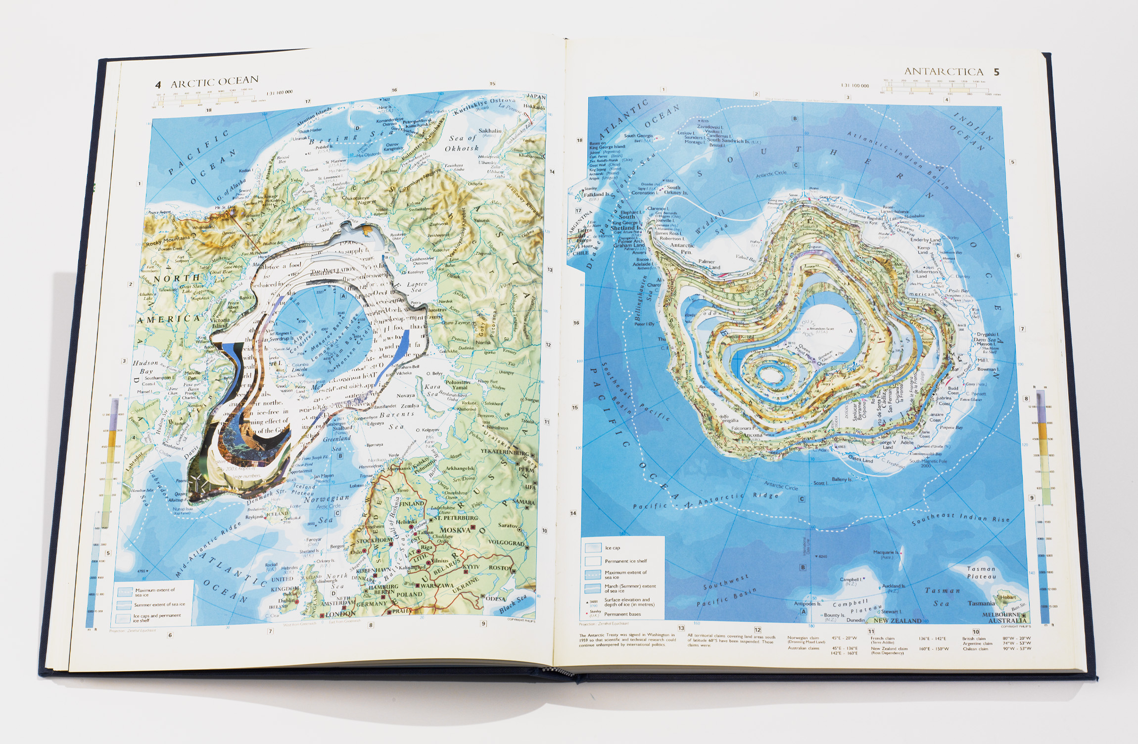 Open atlas book of North and South Poles with pages carved