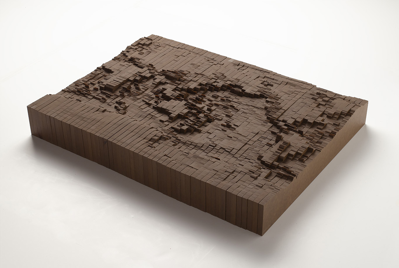 Large rectangular wood sculpture on  that looks like a topographical landscape