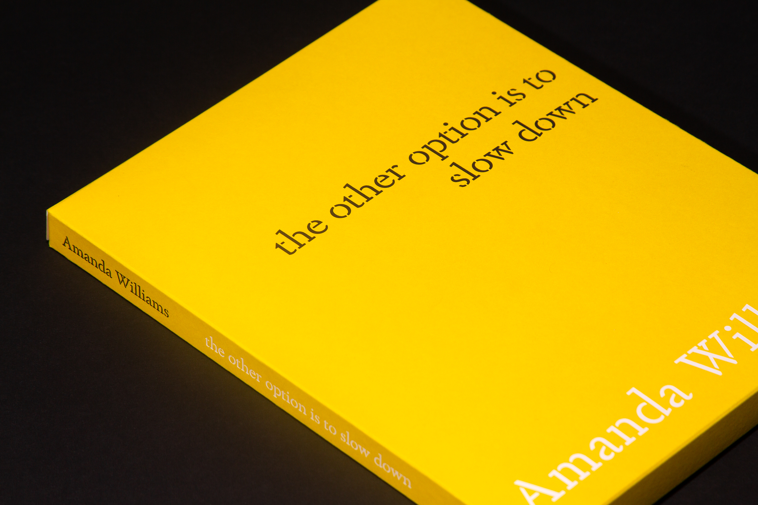 Yellow covered book laying sideways on a black background