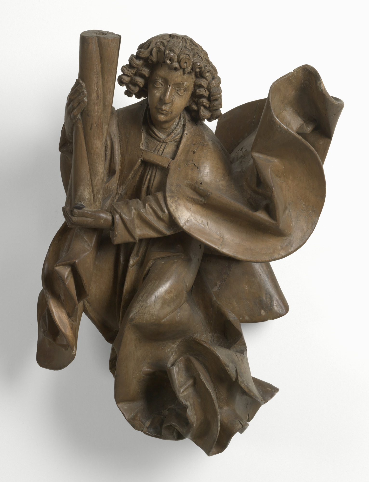Carved wooden angel wearing loose robes, with short curly hair, holding onto a column