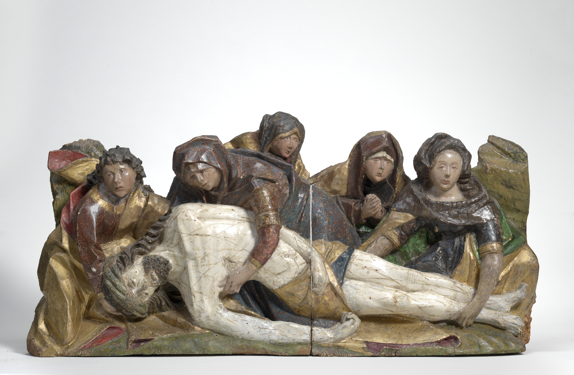 A carved wooden scene of five cloaked women bending over Christ's limp body. 