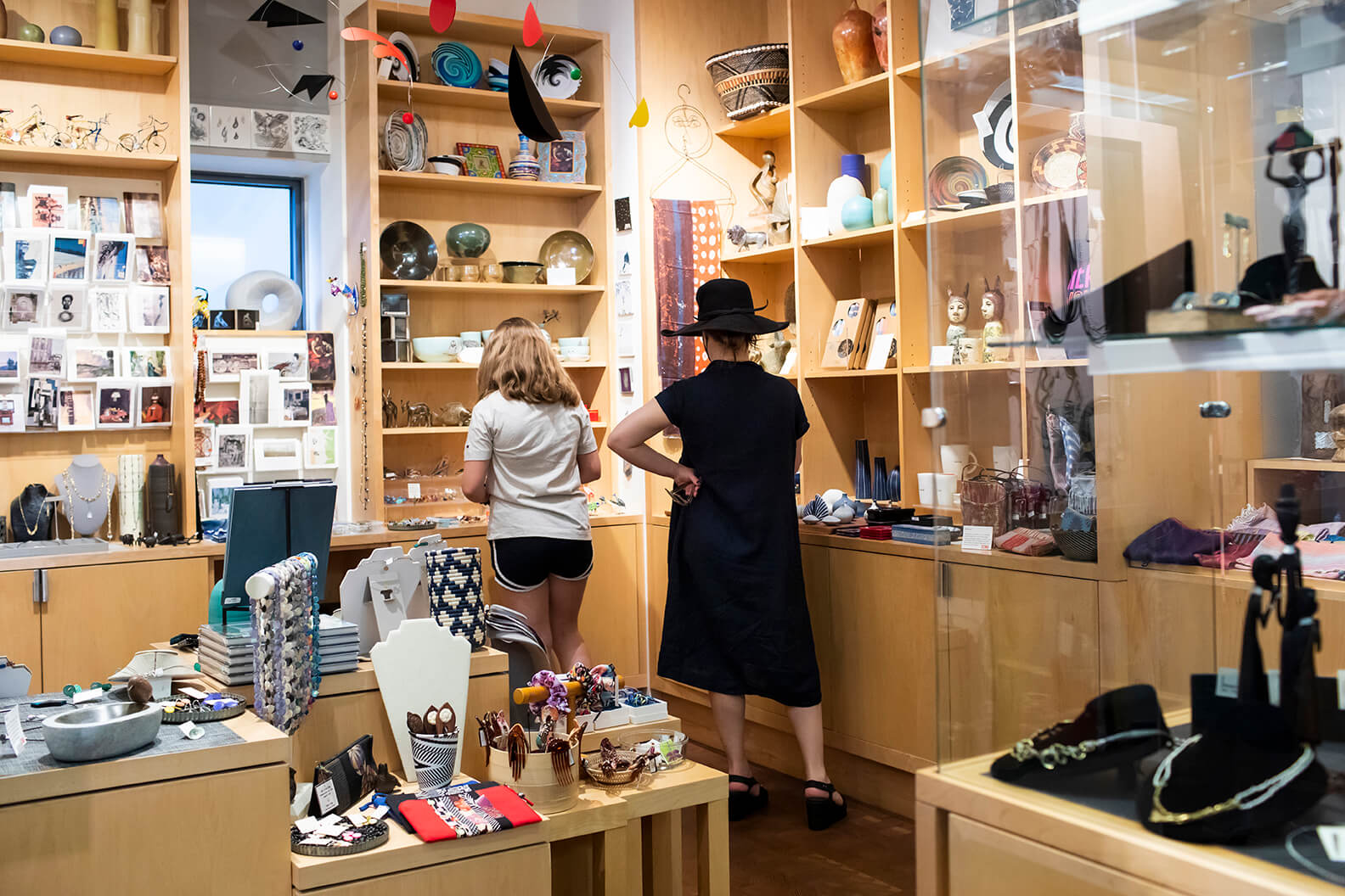 Woman in black dress and hat with child in the SCMA shop