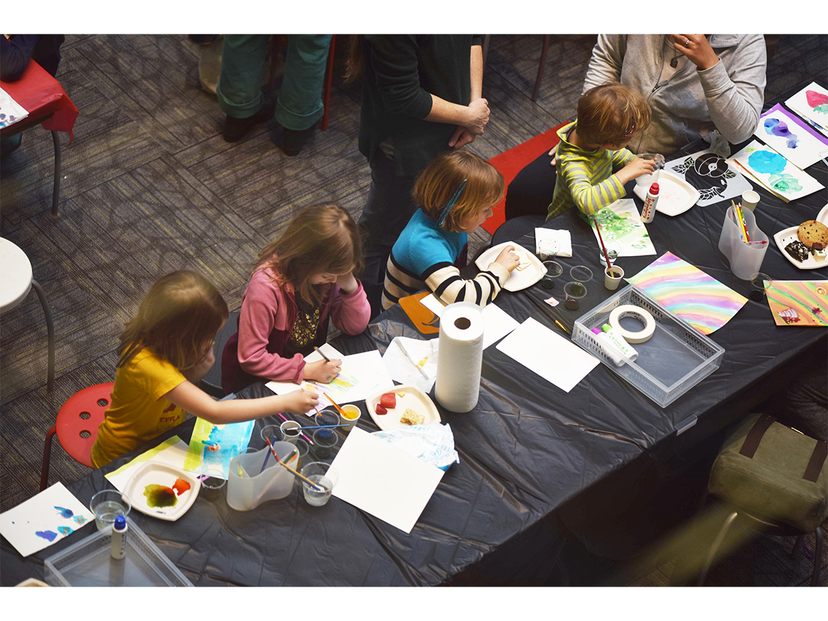 Birds Eye view of 5 children and an adult making art at a table