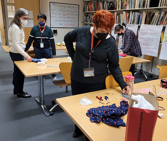 Several people in masks looking at accessories on tables