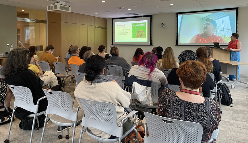 Person giving projeted presentation to a room of people