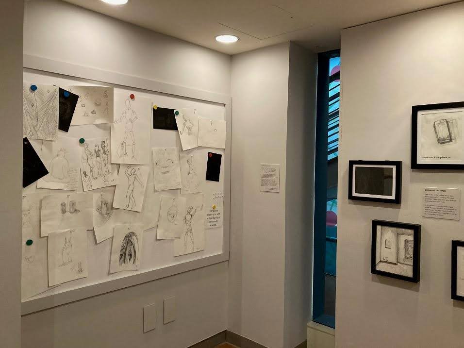 Cluster of drawings visitors to the museum made on the left and selected framed ones on the right..