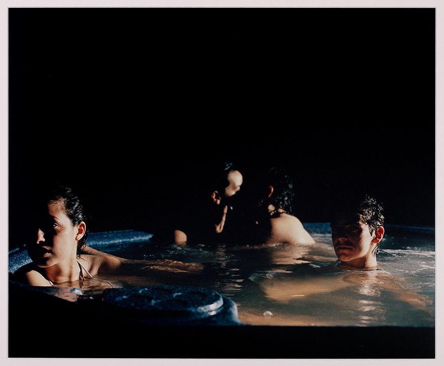 Four people in a hot tub on a dark night