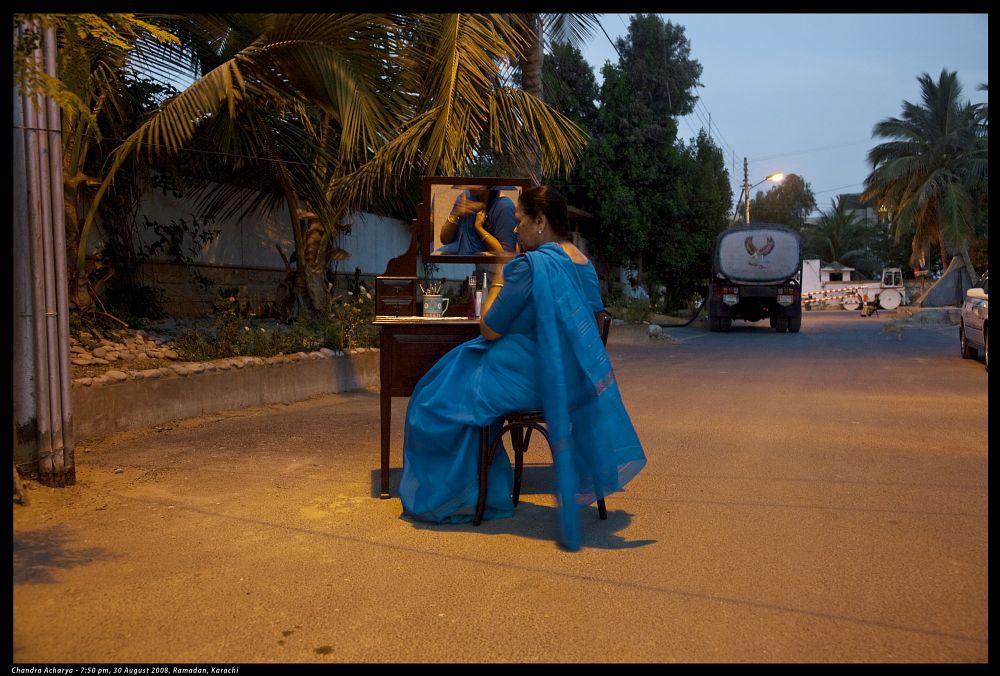 Woman in Sari sitting a a dressing table in the middle of the street with no one around