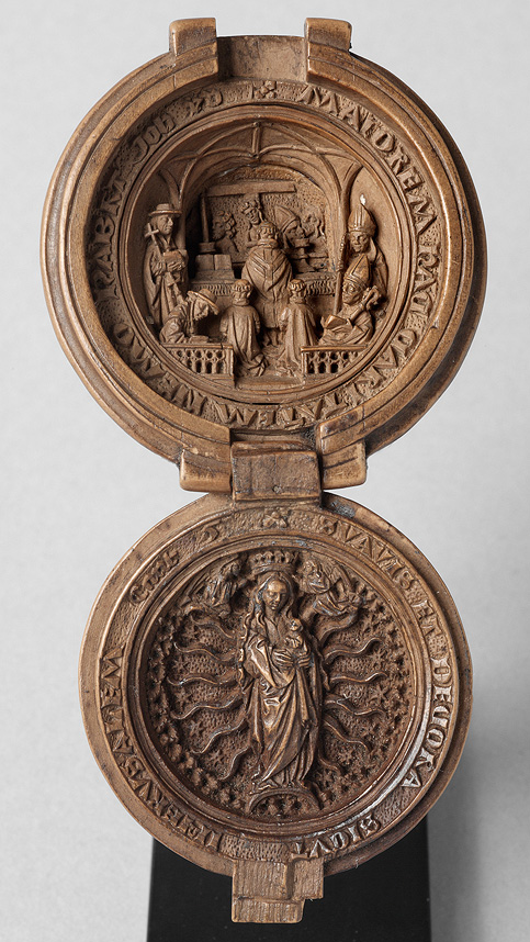Intricately carved spherical bead hinged to open like a tiny portable altar. The upper scene shows Saint Gregory celebrating mass, while Mary the Virgin of the Rosary is below.