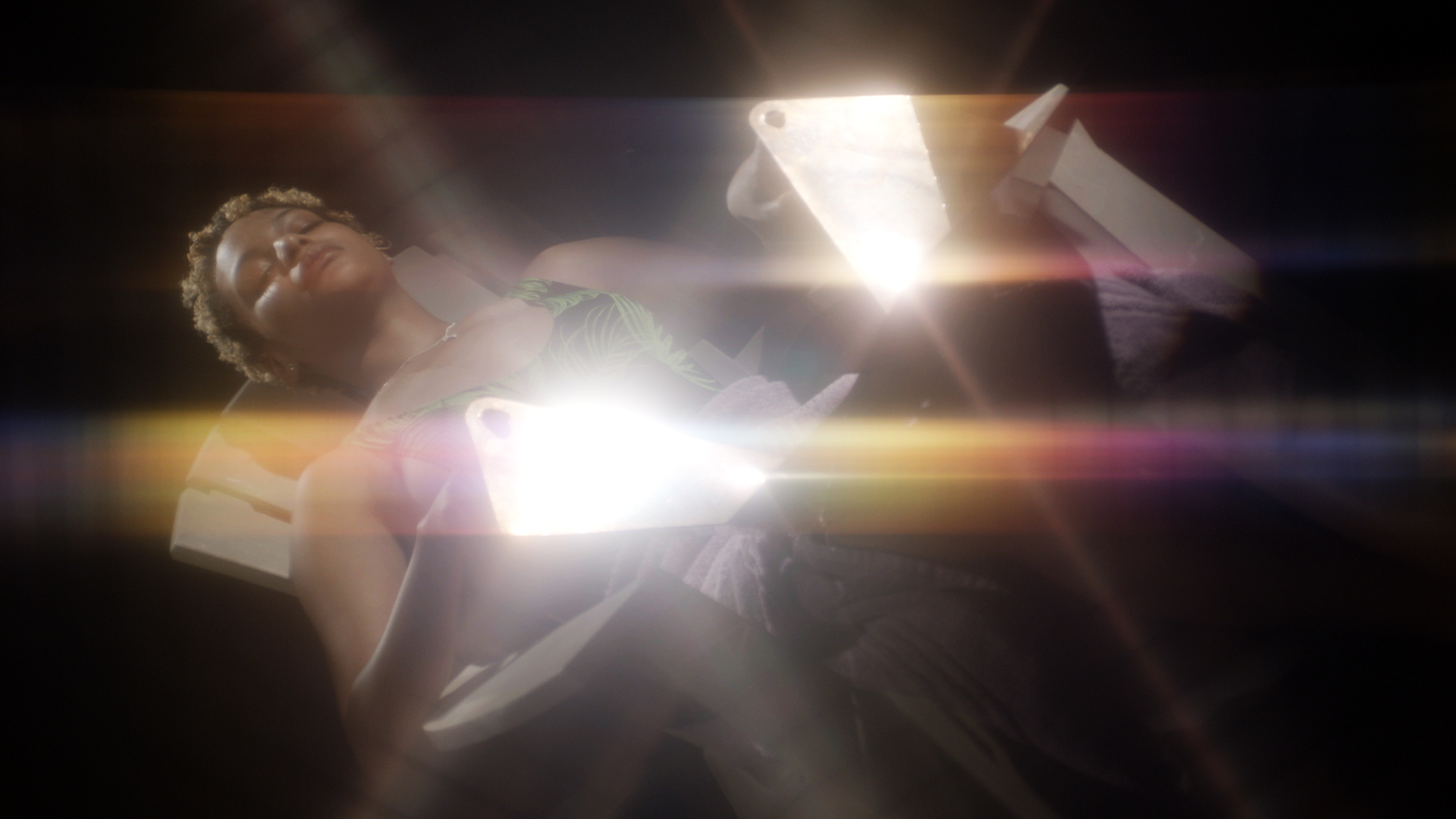 Figure laying on lawn chair reflecting light with mirrors