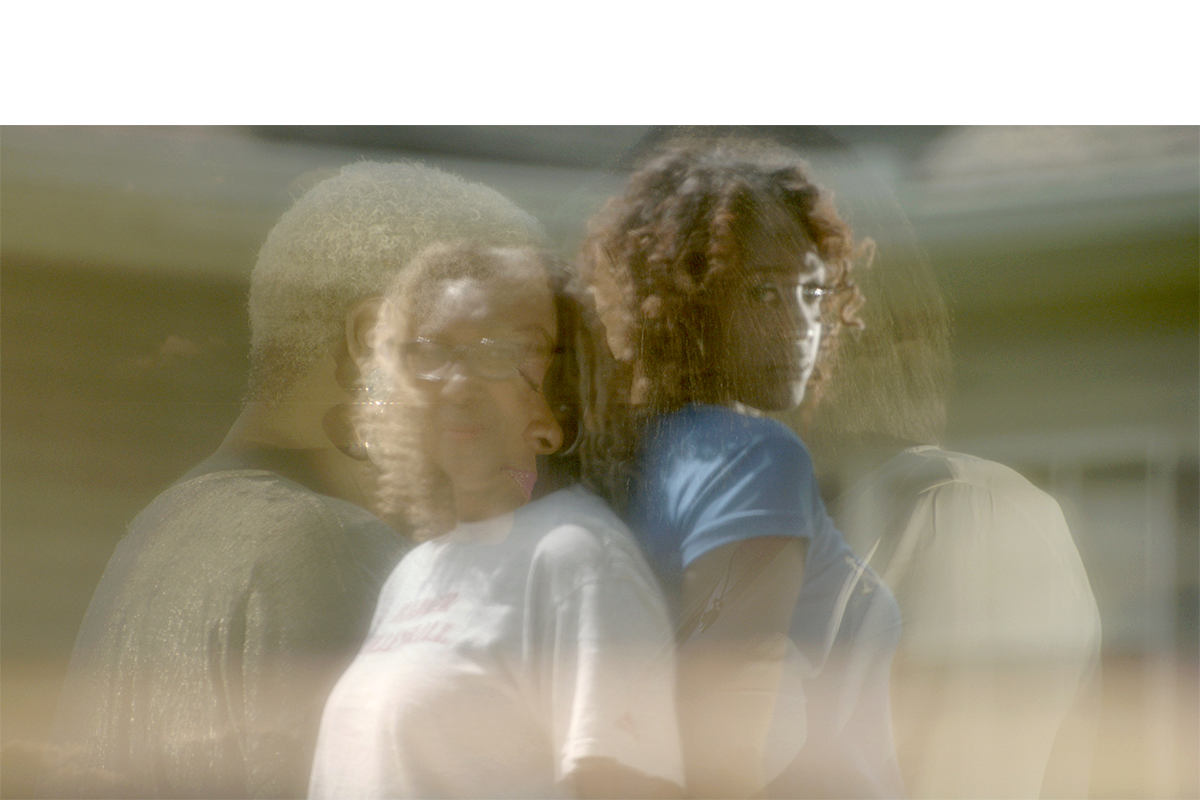 Two faded figures on top of two figures standing back to back