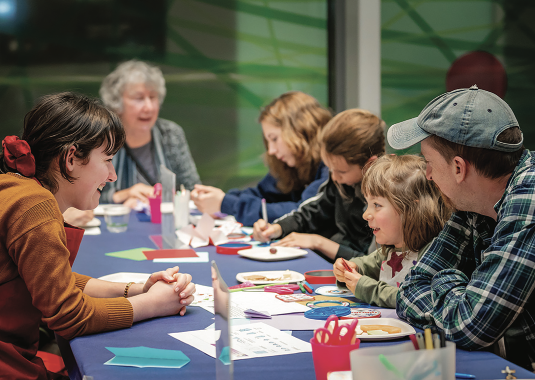 Six People at a table making art and talking to each other