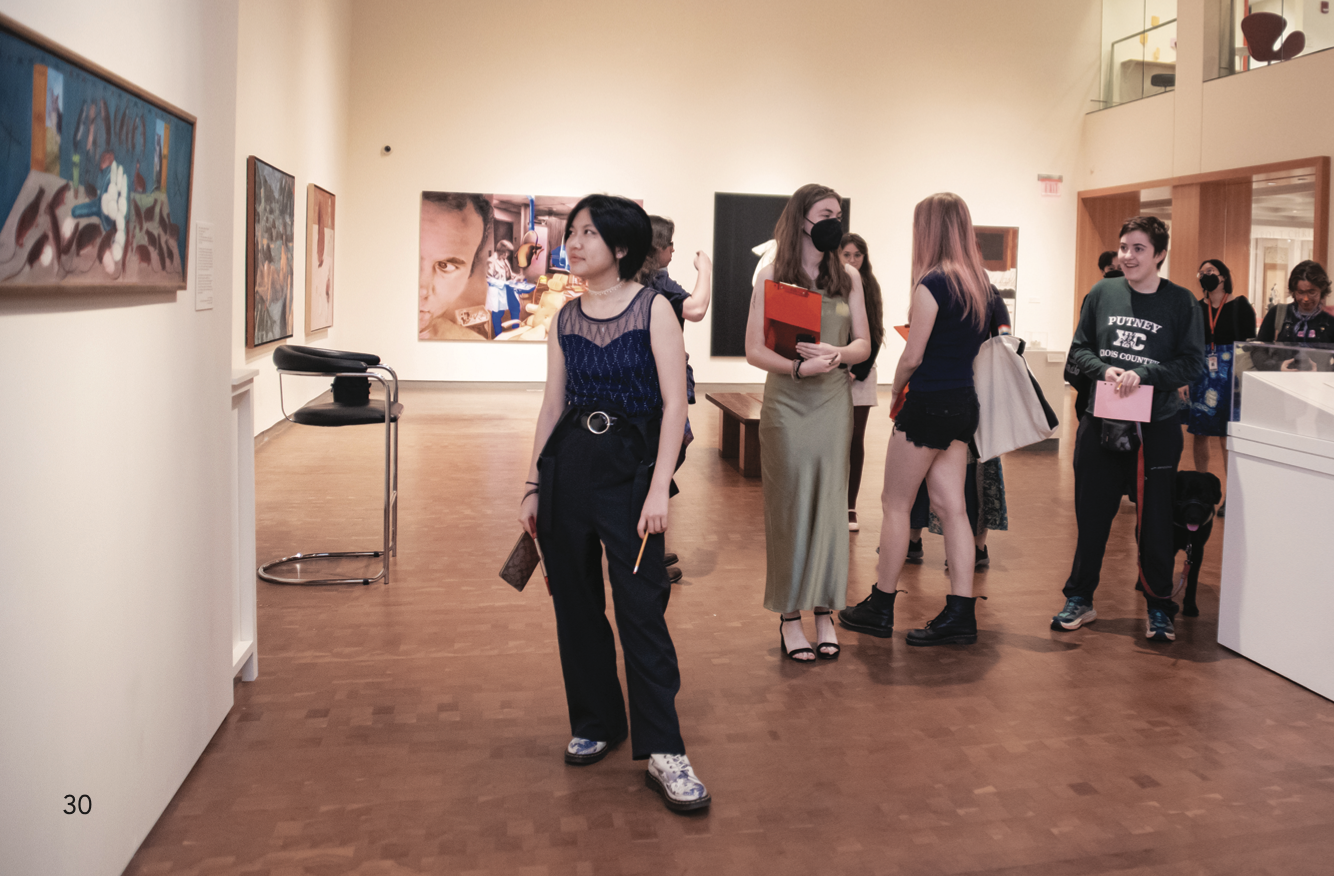 10 students dressed up and in an art gallery with pencils and clip boards