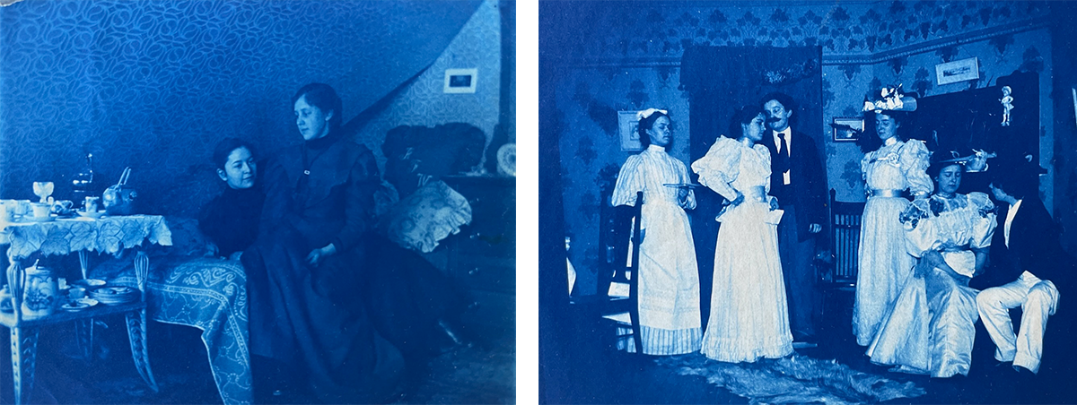  Two blue photographs. At right, a photo of two young women sitting on a bed, one on the other’s lap, with a small table arranged for a meal to their side. At left, a photo of four young women and two young women dressed formally in white dresses and suits in a room with flowered wall paper. 