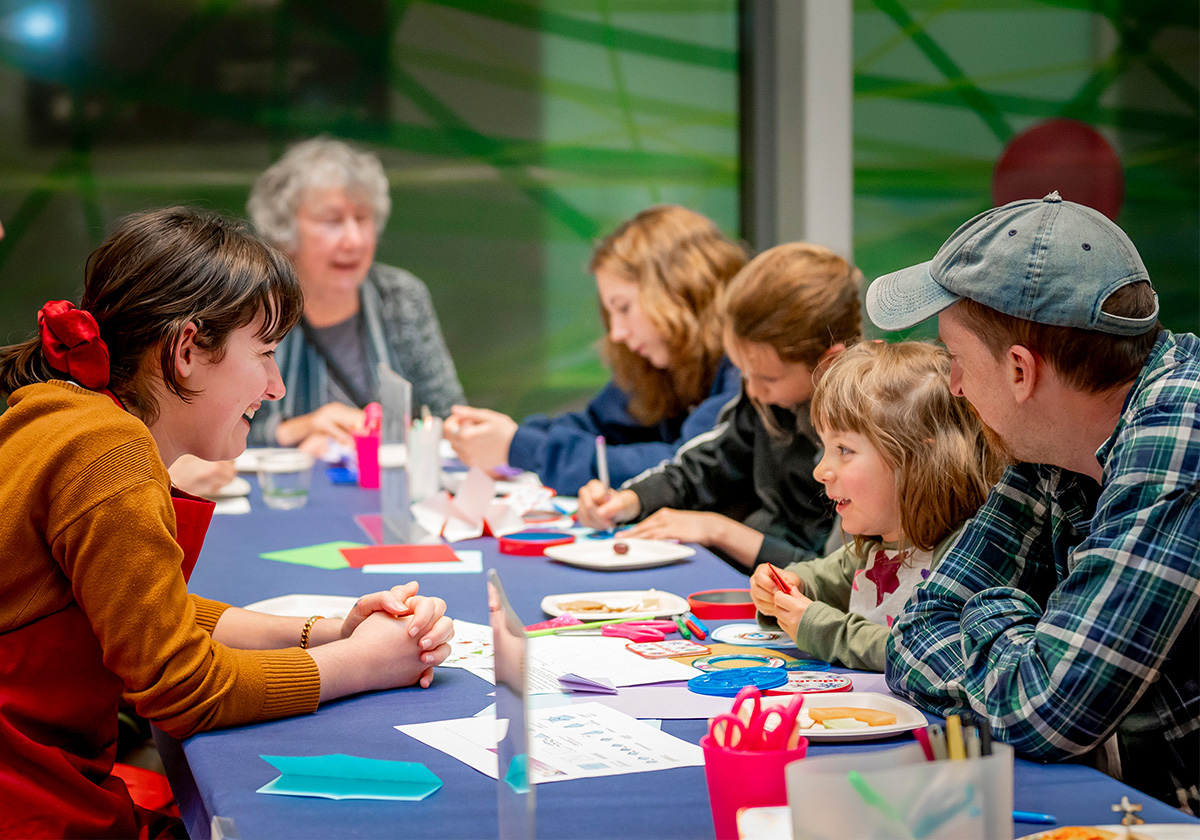 people around a table making art together