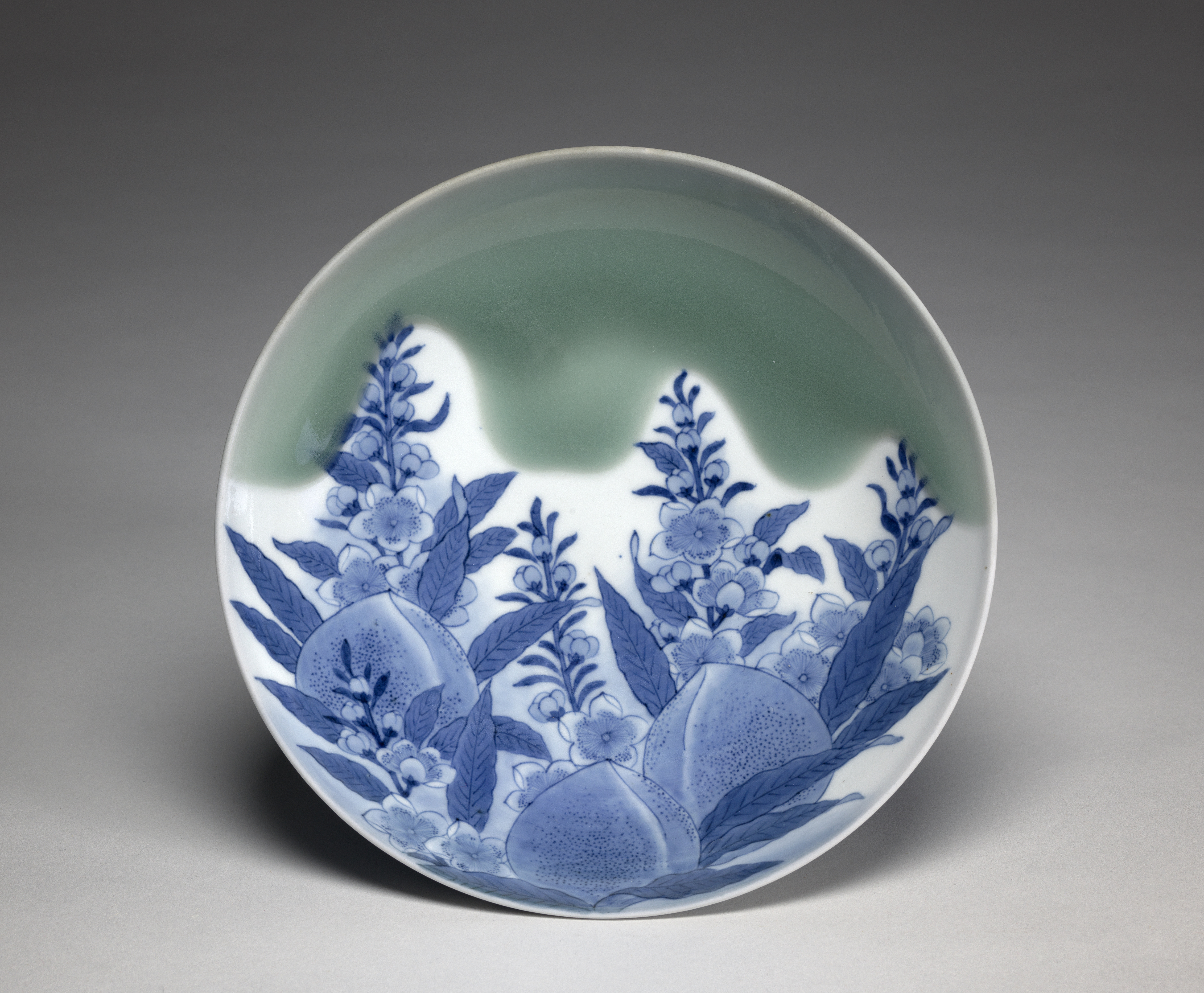 Plate with blue glaze of three peaches with leaves