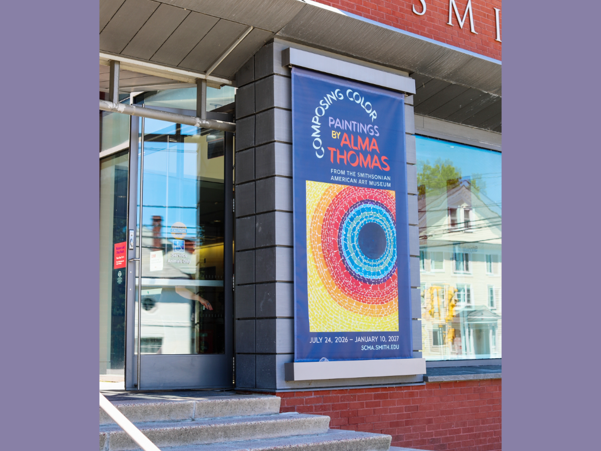 Banner on a brick building with glass door opening on left. Banner reads Composing Color: Paintings by Alma Thomas from the Smithsonian American Art Museum with exhibition dates July 24, 2026–January 10, 2027, scma.smith.edu