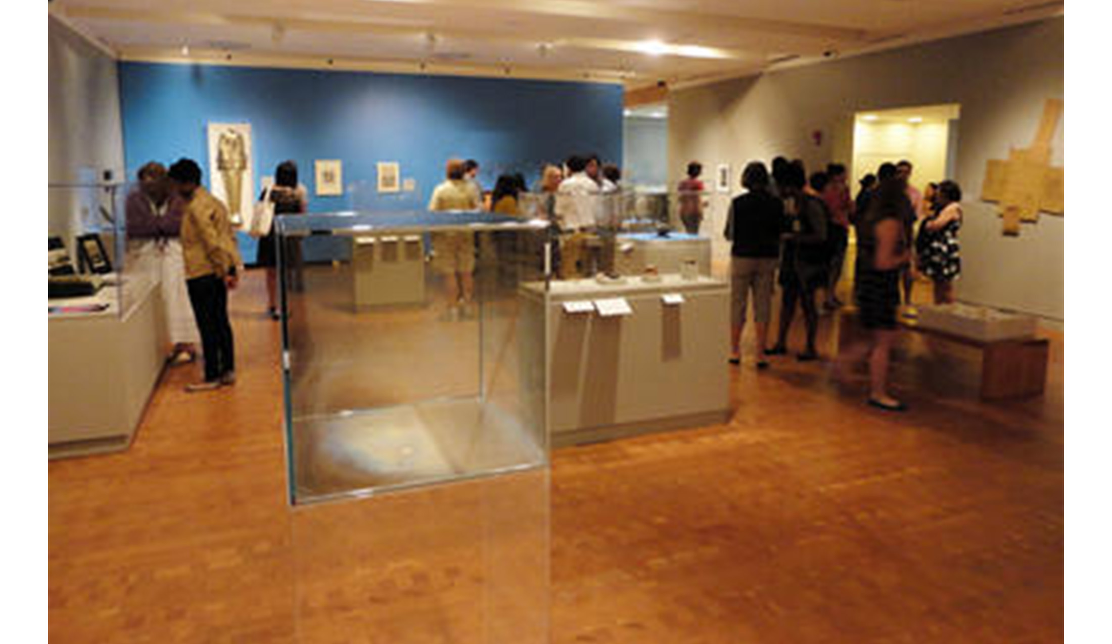 art gallery full of visitors looking at various display cabinets