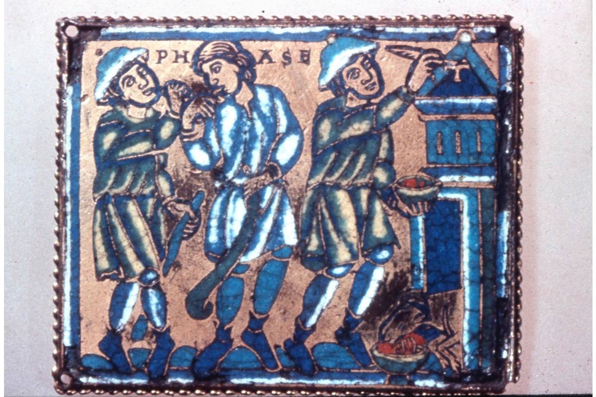 "Rectangular copper champlevé enamel plaque with a representation of the Passover: man painting Tau cross on house, while two other men stand nearby, with dog, eating; inscribed."