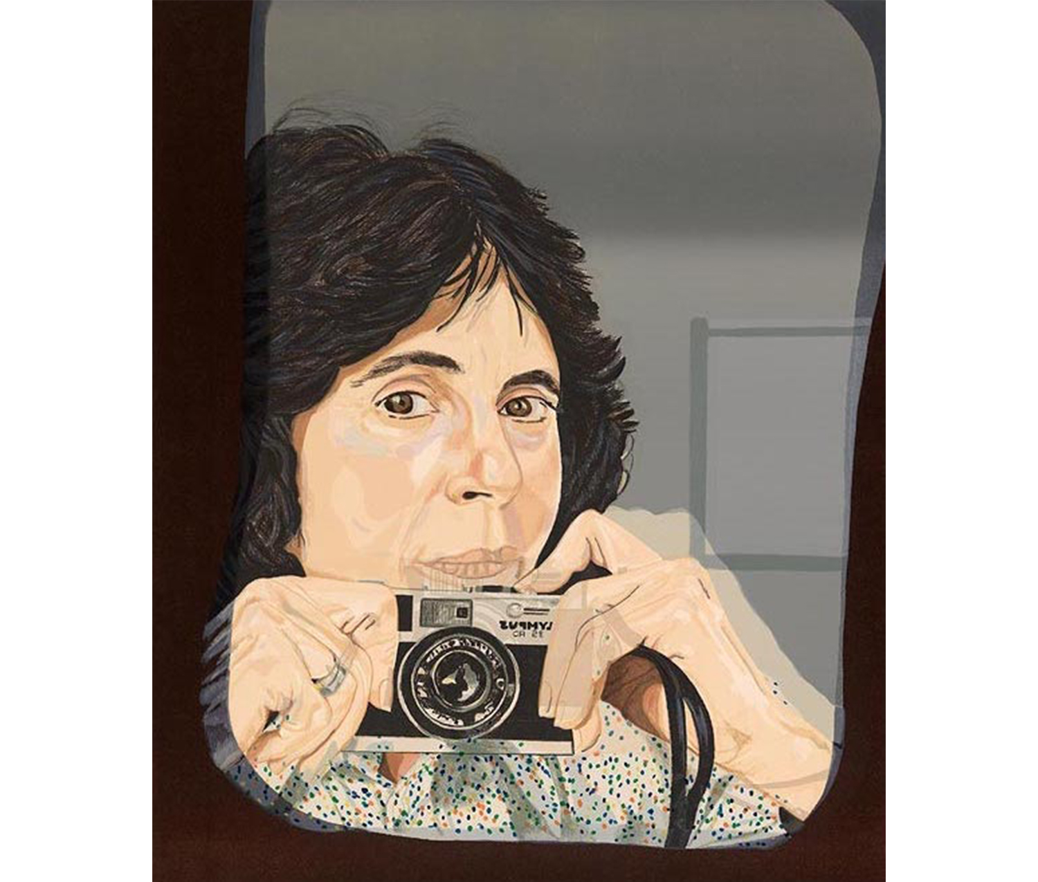 close-up of young woman with dark mid-length hair and brown eyes, wearing white shirt with polka-dots seen in mirror taking a picture of herself with an Olympus camera