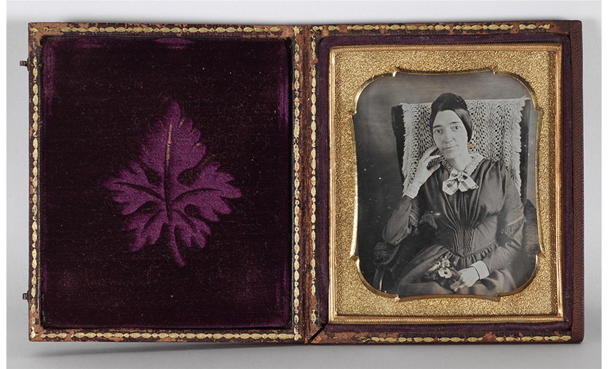 open picture frame. deep purple velvet on the left side. frontal portrait of a seated woman on the right side.