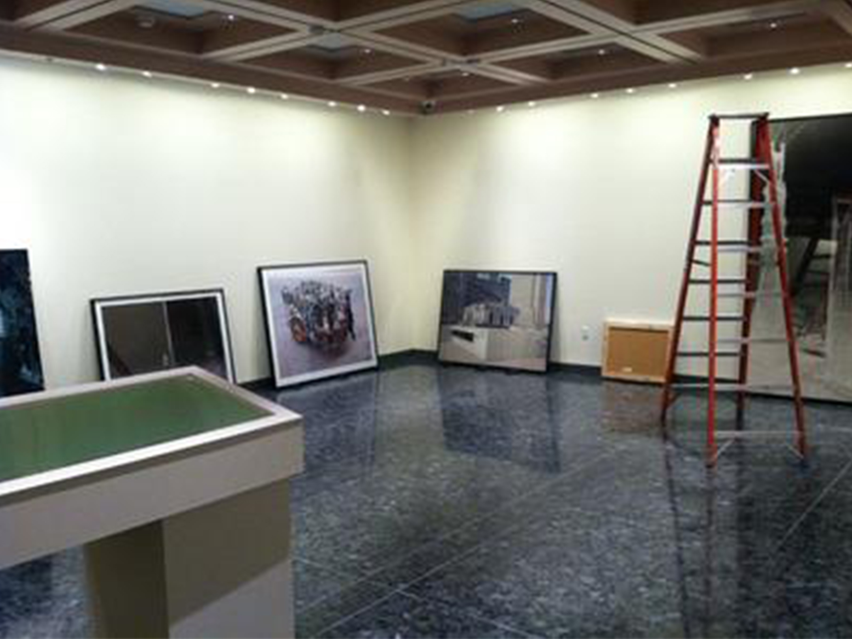 gallery space. framed artworks sitting on the ground waiting to be hung.