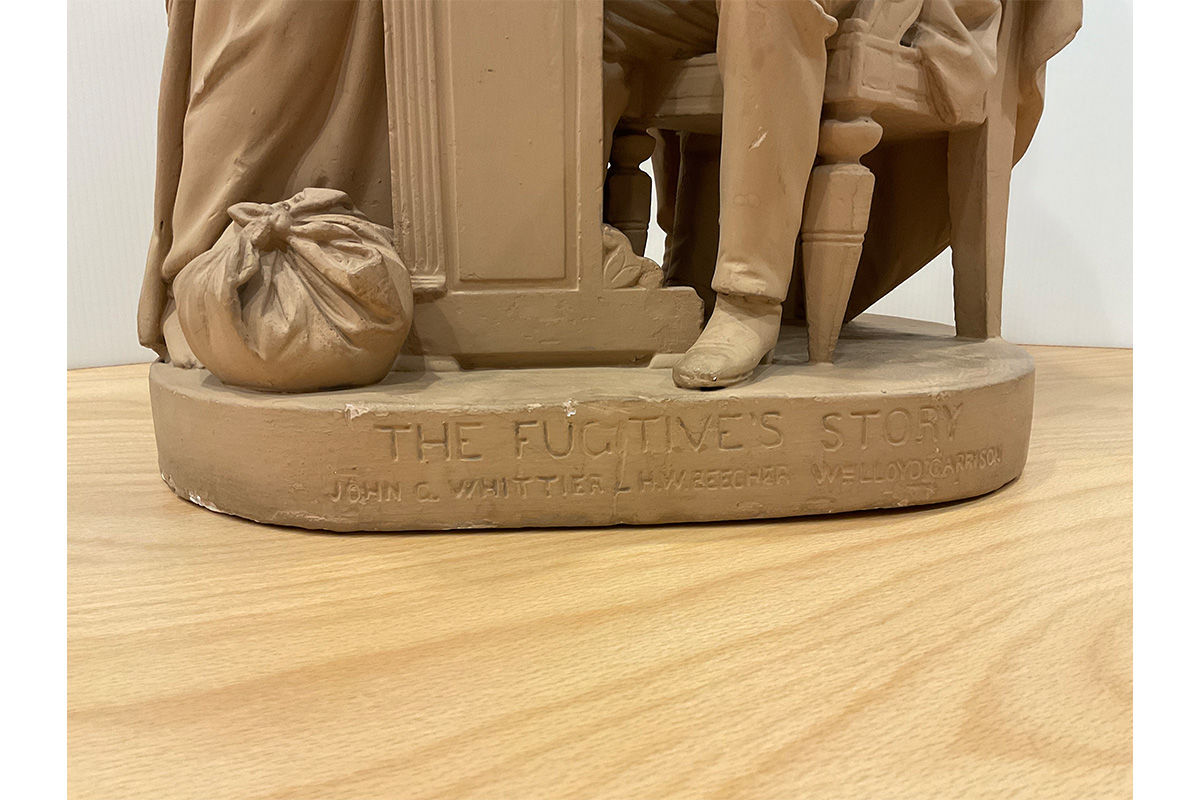 "Text written at base of statue reading: 'The Fugitive's Story / John G. Whittier - H.W. Beecher - W Lloyd Garrison"
