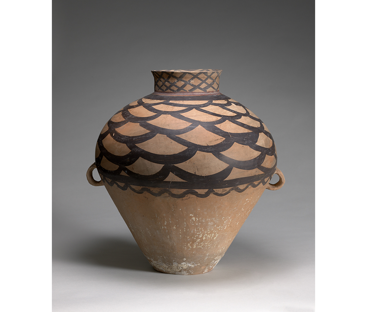 beige earthenware vessel with painted scalloped decoration along the top