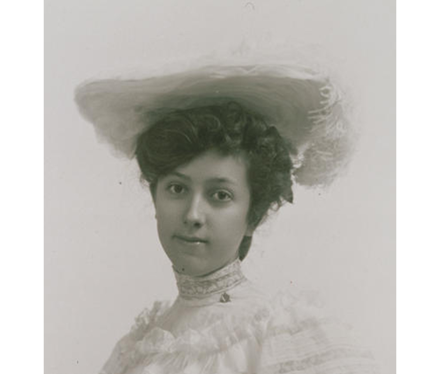 close-up of woman with fancy updo in her hair, wearing a white hat and a white dress with a high collar