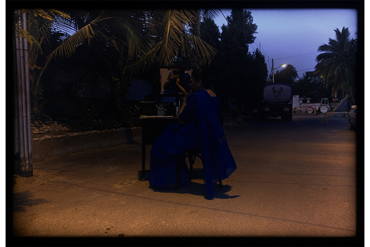 "evening, woman in sari seated outdoors"