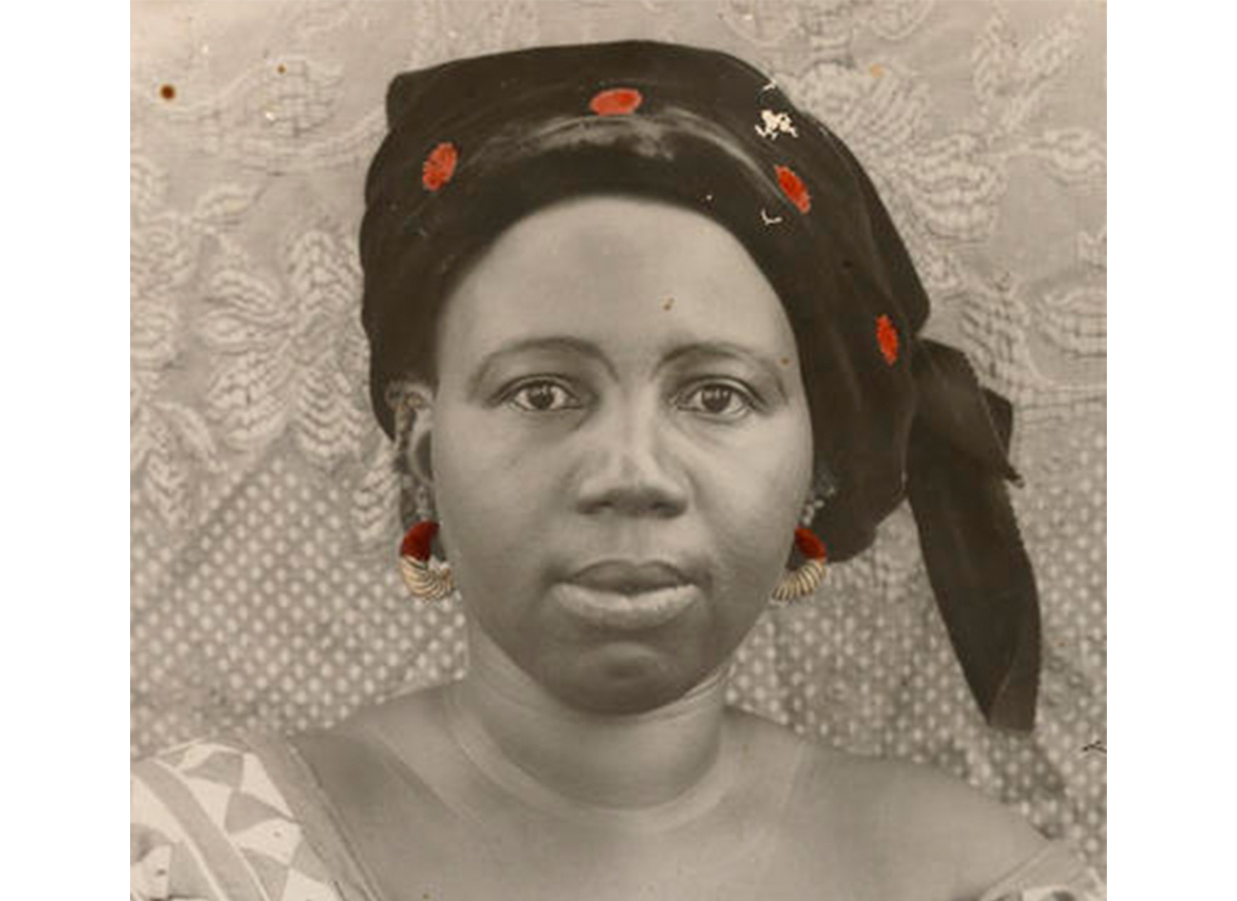 close-up of woman wearing black and red scarf on head, red earrings