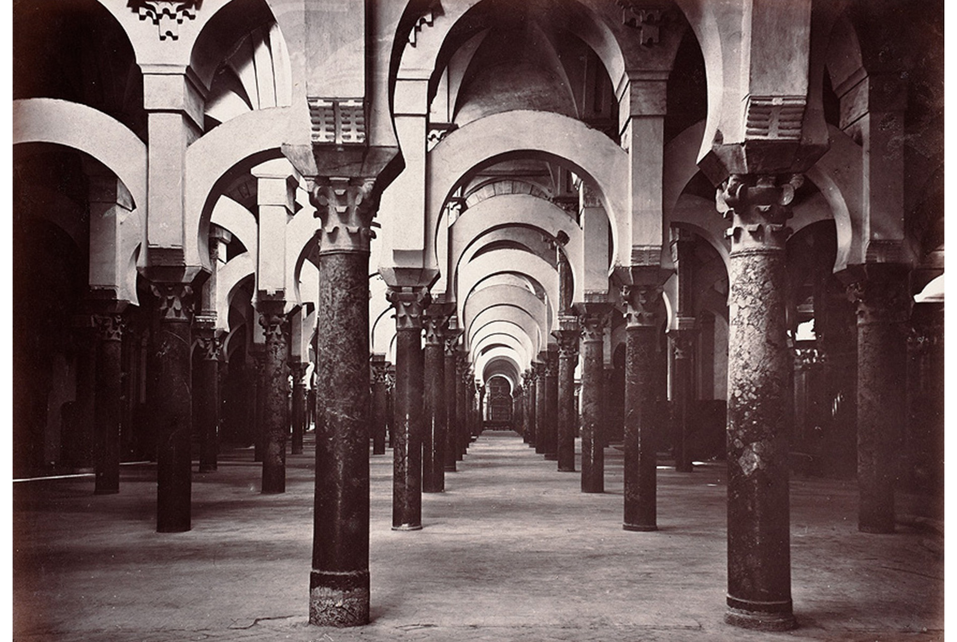 interior hall of a mosque, with columns from floor to ceiling and arches along the ceiling