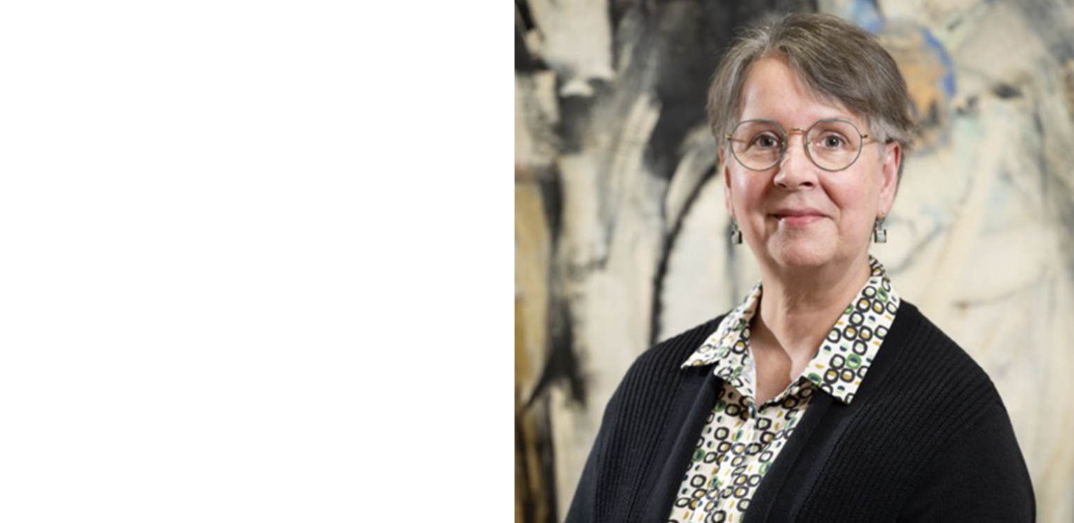 Person in front of a painting wearing glasses and a black sweater